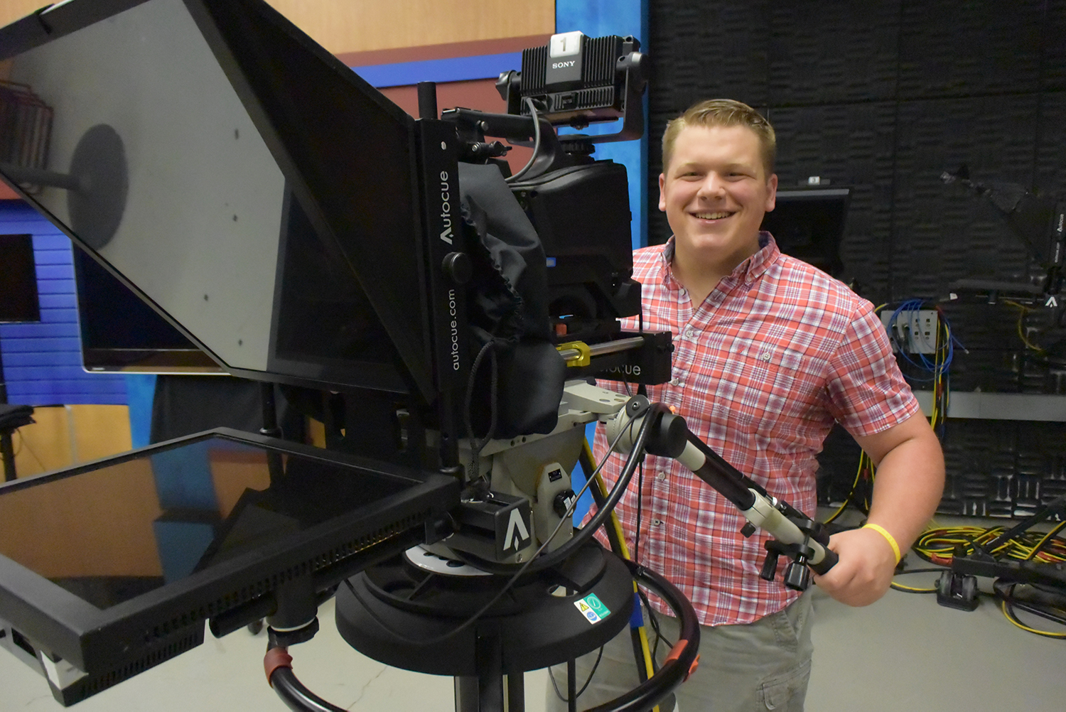 A student learning how to use camera equipment