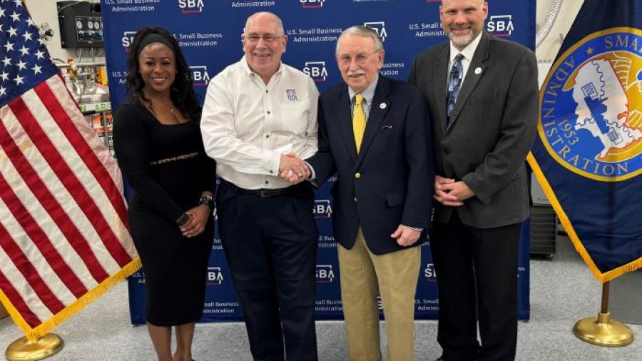 Mike Mowins (white shirt) is presented with the New York Veteran Owned Small Business of the Year Award by Paul Brooks of OCC's SBDC. Also pictured are (left) New York State SBDC Director Sonya Smith and (right) OCC SBDC Regional Director Bob Griffin.
