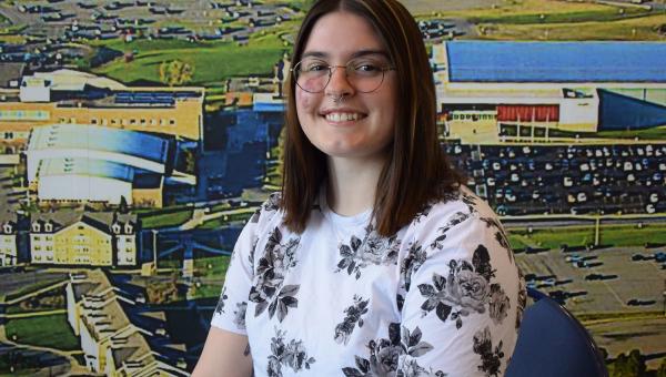 An OCC student in front of a colorful background