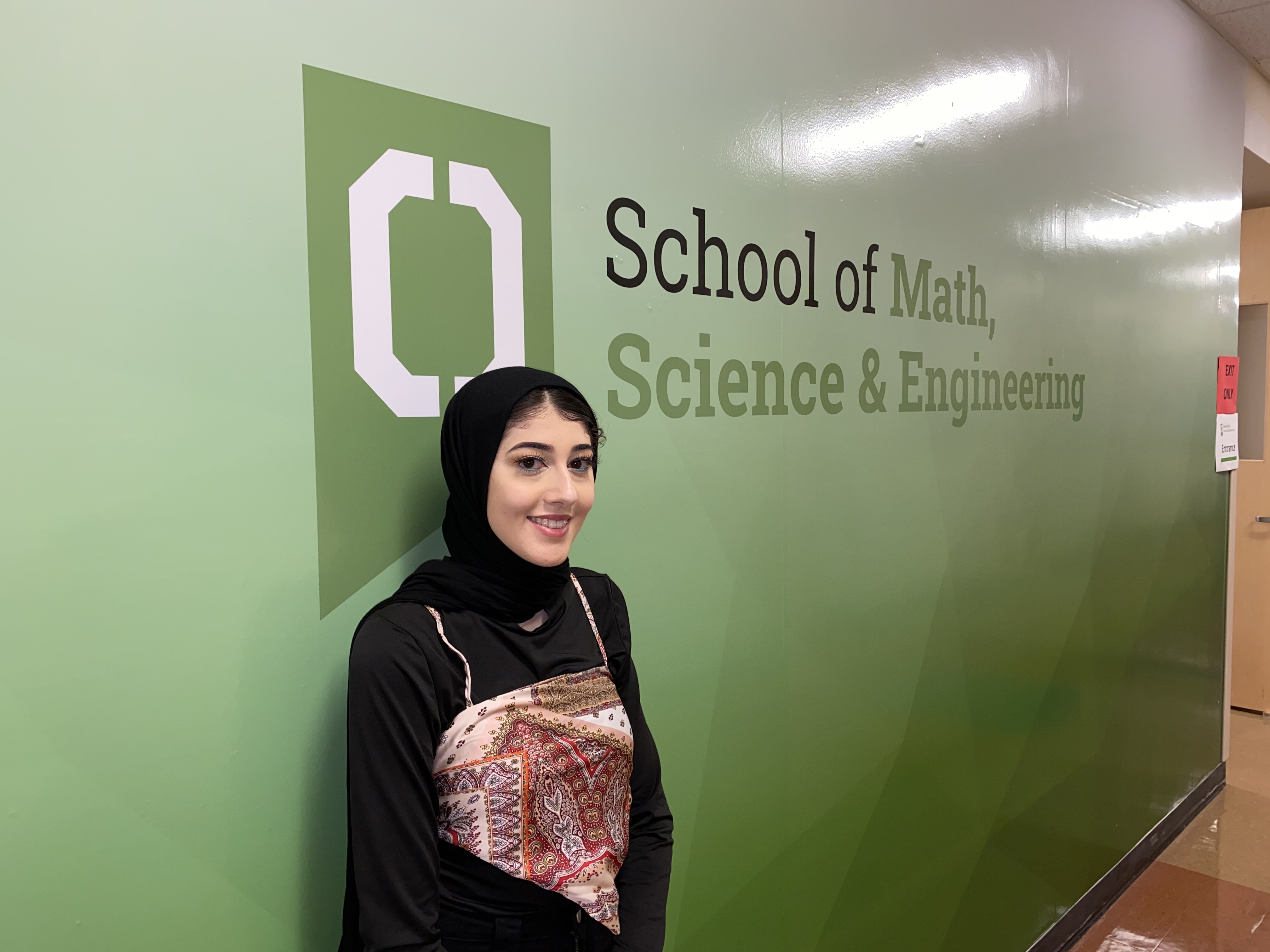 Woman stands in front of the School of Math, Science & Engineering 