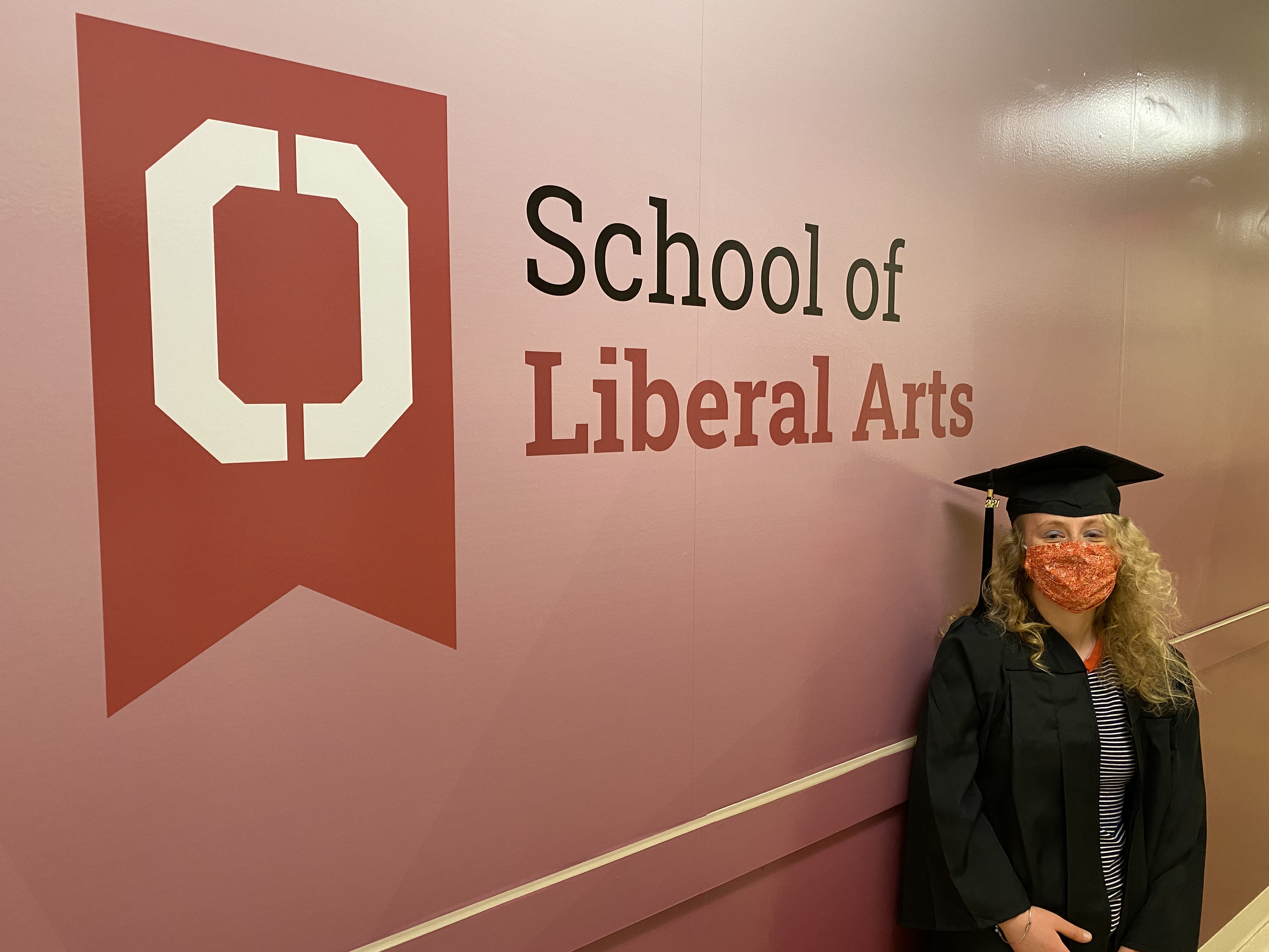 Student in front of the School of Liberal Arts 