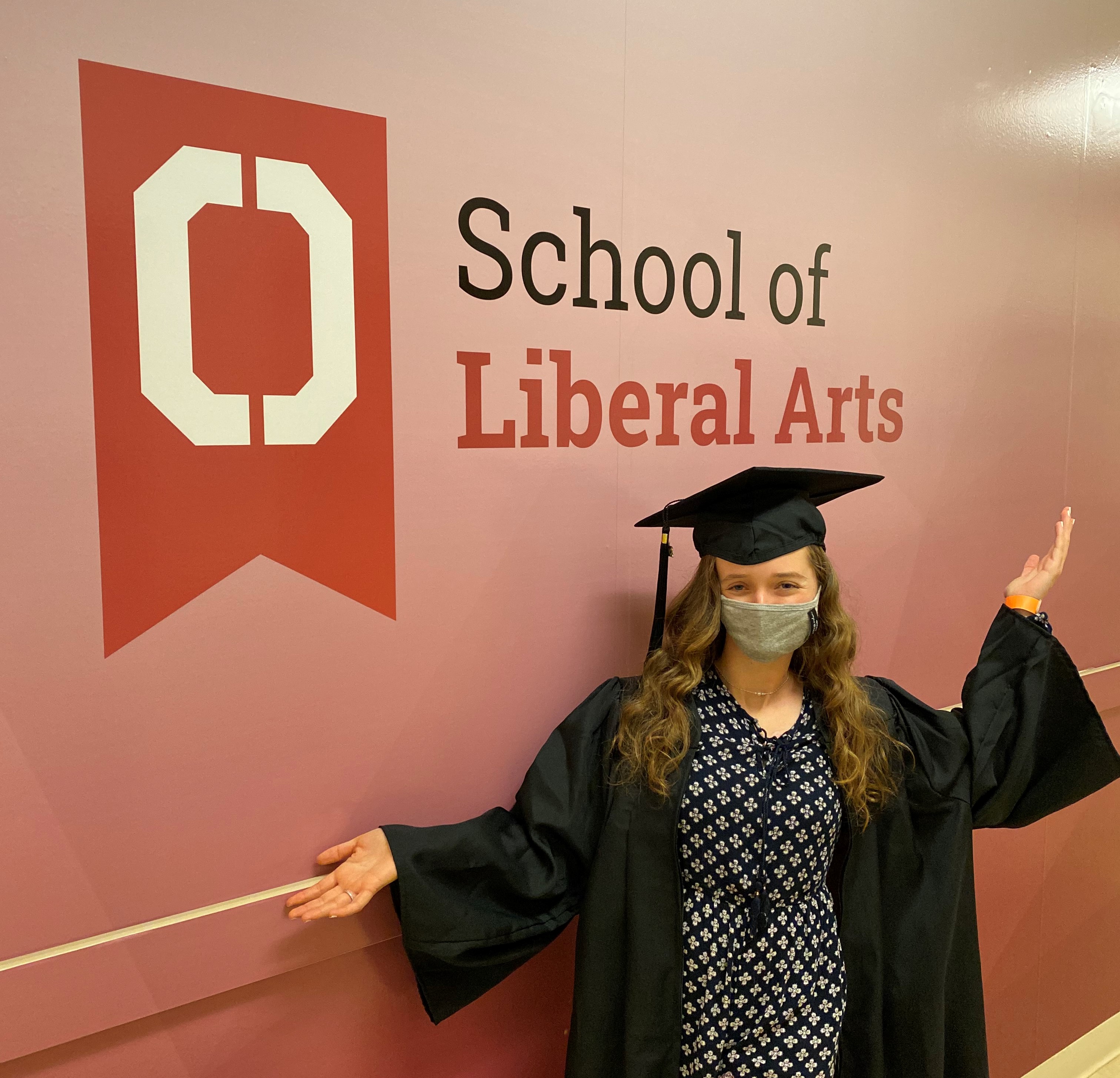 Woman standing in front of a sign that says School of Liberal Arts 