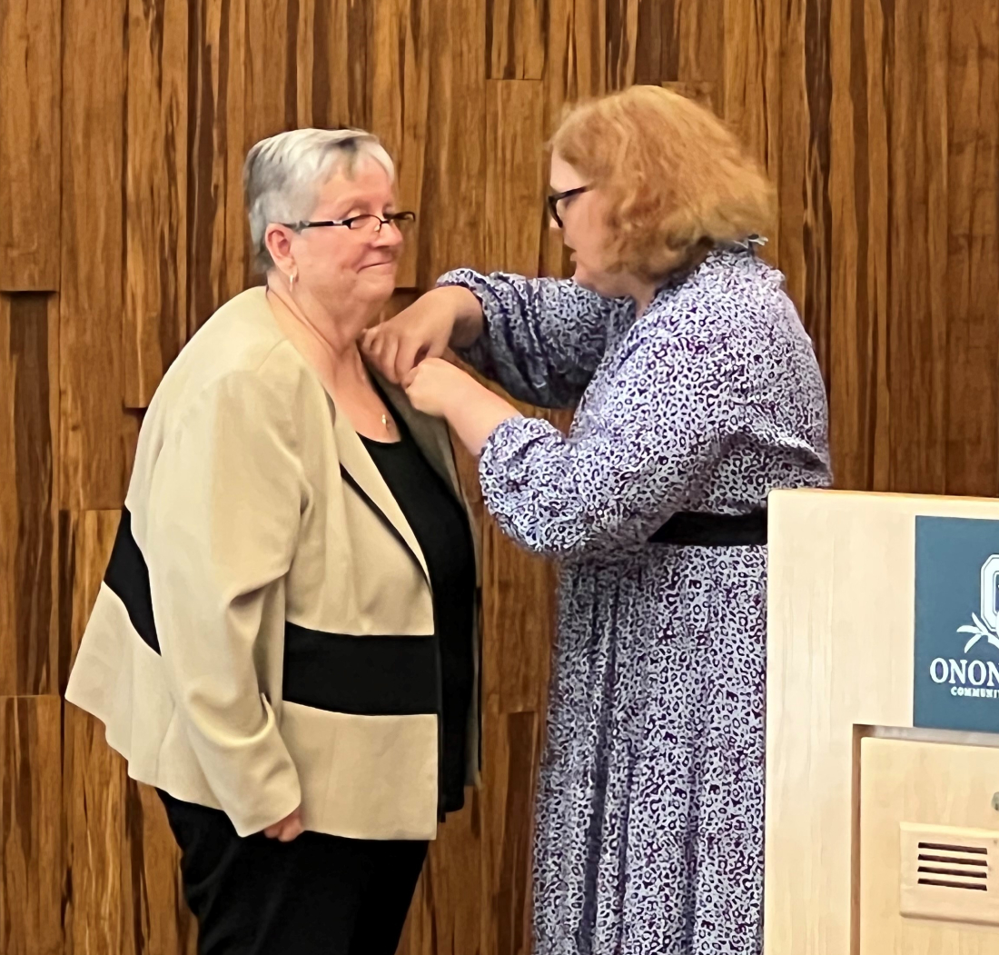 Retiring OCC President Dr. Casey Crabill (left) was presented with an honorary Nursing pin by Nursing Professor Lee Berg (right).