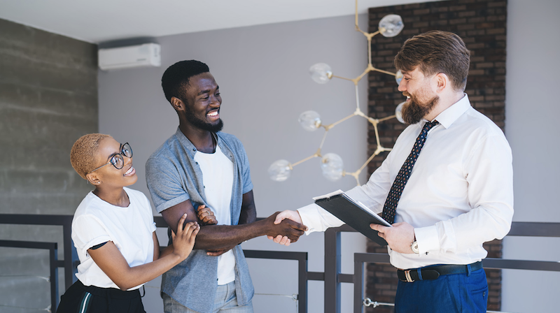 Realtor shaking hands with new home buyers