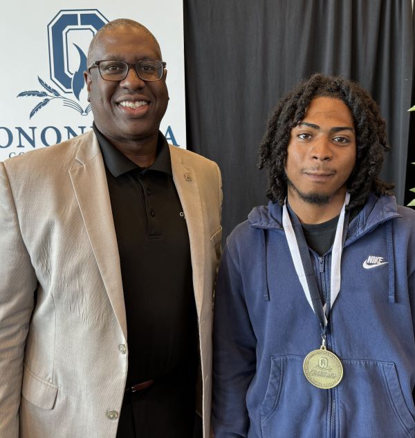 Jaedin Roget-Feimster (right) is presented a Trustee Award by OCC President Dr. Warren Hilton (left).