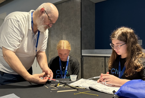 Professor Richard Mark (standing) guided students through the process of building a hydraulic claw.