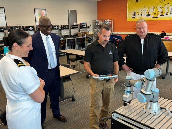 Professor Mike Grieb (holding tablet) demonstrates robotics in the Whitney Applied Technology Center.