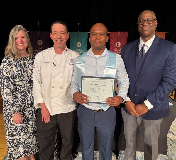 Albadir Mcknight (holding certificate) was named the top student in the Supply Chain Management degree program. He's pictures with (left to right) Provost Anastasia Urtz, Chef James Taylor who presented him the award, and OCC President Dr. Warren Hilton.