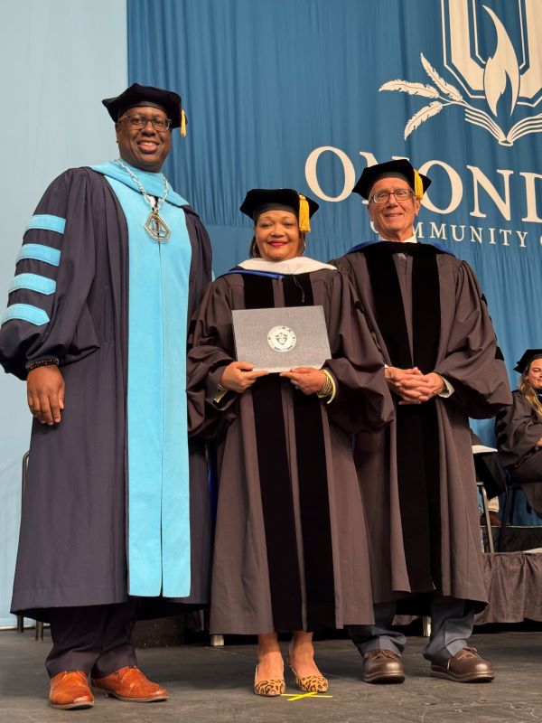 Melanie Littlejohn (center) was presented a SUNY Honorary degree by OCC President Dr. Warren Hilton (left) and Board of Trustees Chair John Sindoni (right).