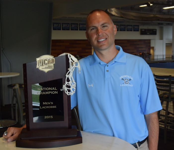 Chuck Wilbur is pictured with the OCC Men's Lacrosse team's 2015 National Championship trophy. Wilbur guided the Lazers to 11 national championships, and was recently recognized with a national award.
