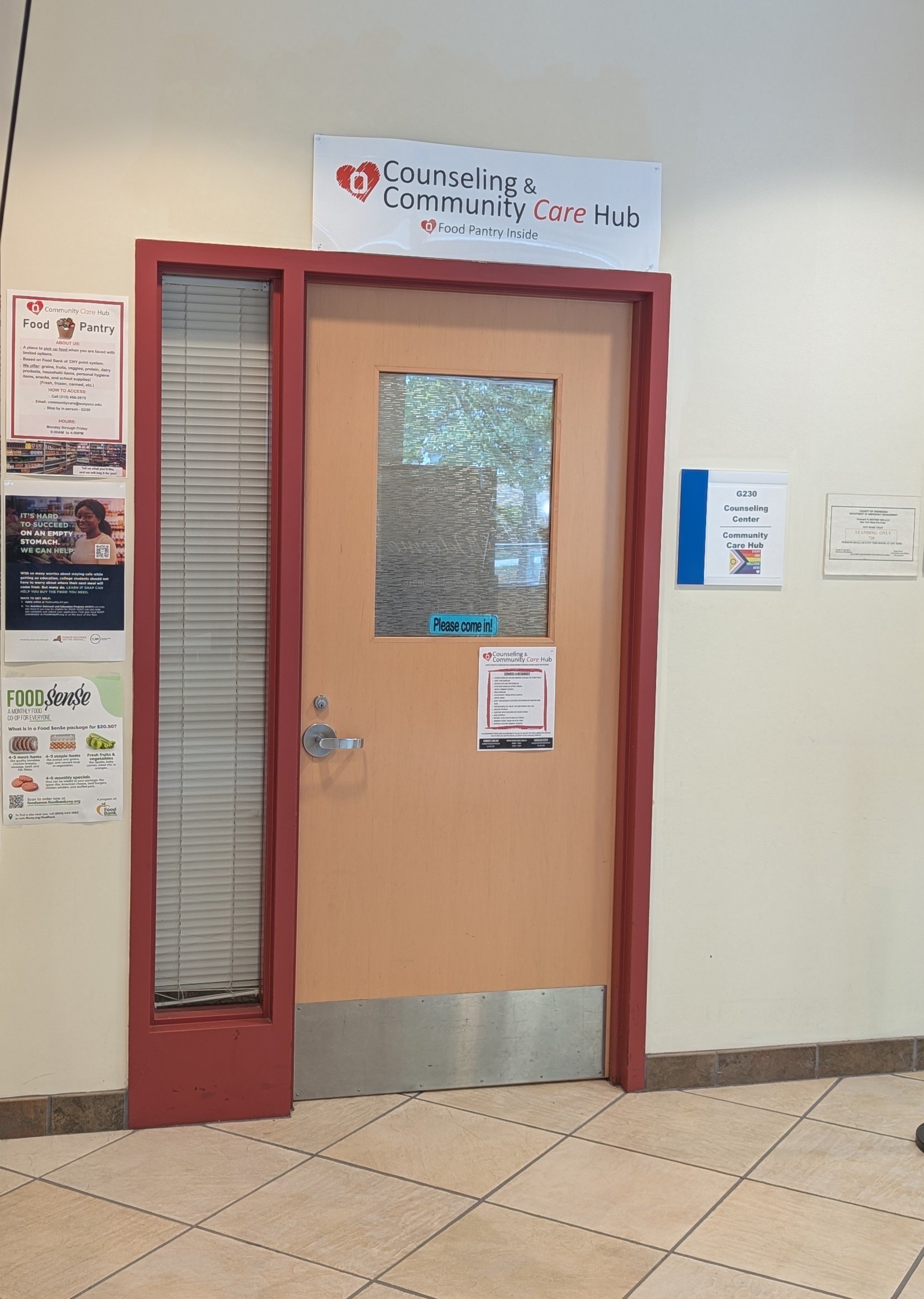 Doorway to Counseling & Community Care Hub with signs about services and food pantry.