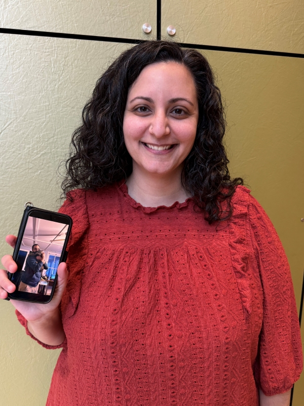 Dana Acee holds up a picture of her twin brother Marc (whose face is partially hidden by his cat Franny).