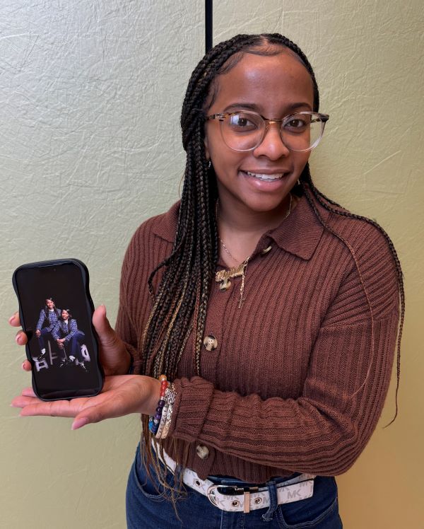 Najier Johnson holds up a picture of herself with her twin sister Najah.