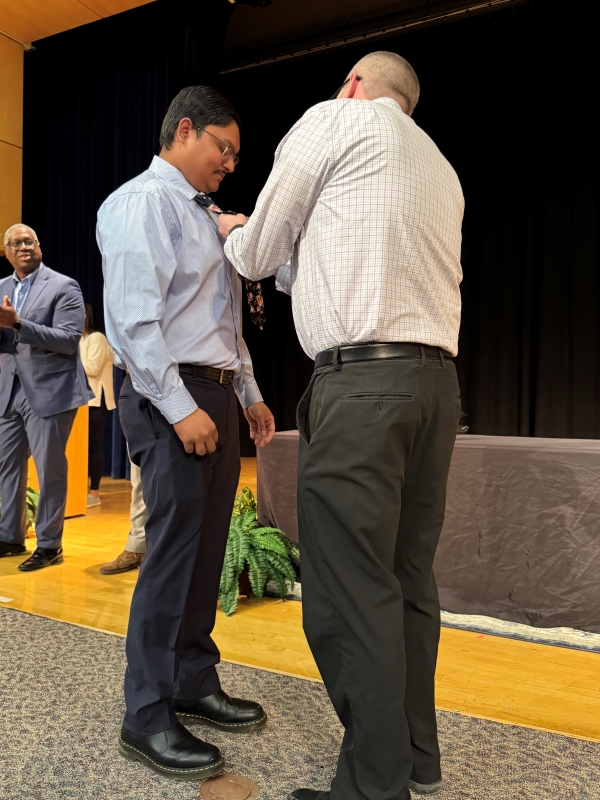 Graduating Nursing student Mohammad Afsar receives his Nursing pin from OCC Nursing Professor Brian Kling.