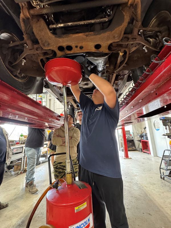 OCC Automotive Technology students demonstrated maintenance techniques, like changing oil.