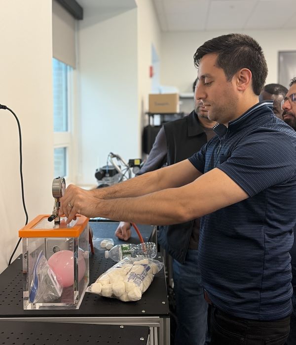 Sayed Ehsanullah Ahmady gets hands-on learning experience during an "Introduction to Vacuum Systems" session. It provides students the opportunity to explore core vacuum principles including the relationships between pressure, force, area, volume, and temperature.