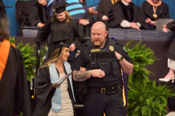 Graduate Ava Falvo is escorted from the stage by her uncle, OCC Campus Safety Police Chief Jeff Peckins.