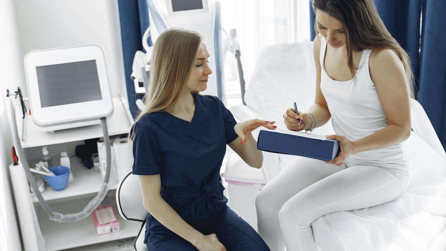 Nursing Assistant helping a woman with paperwork