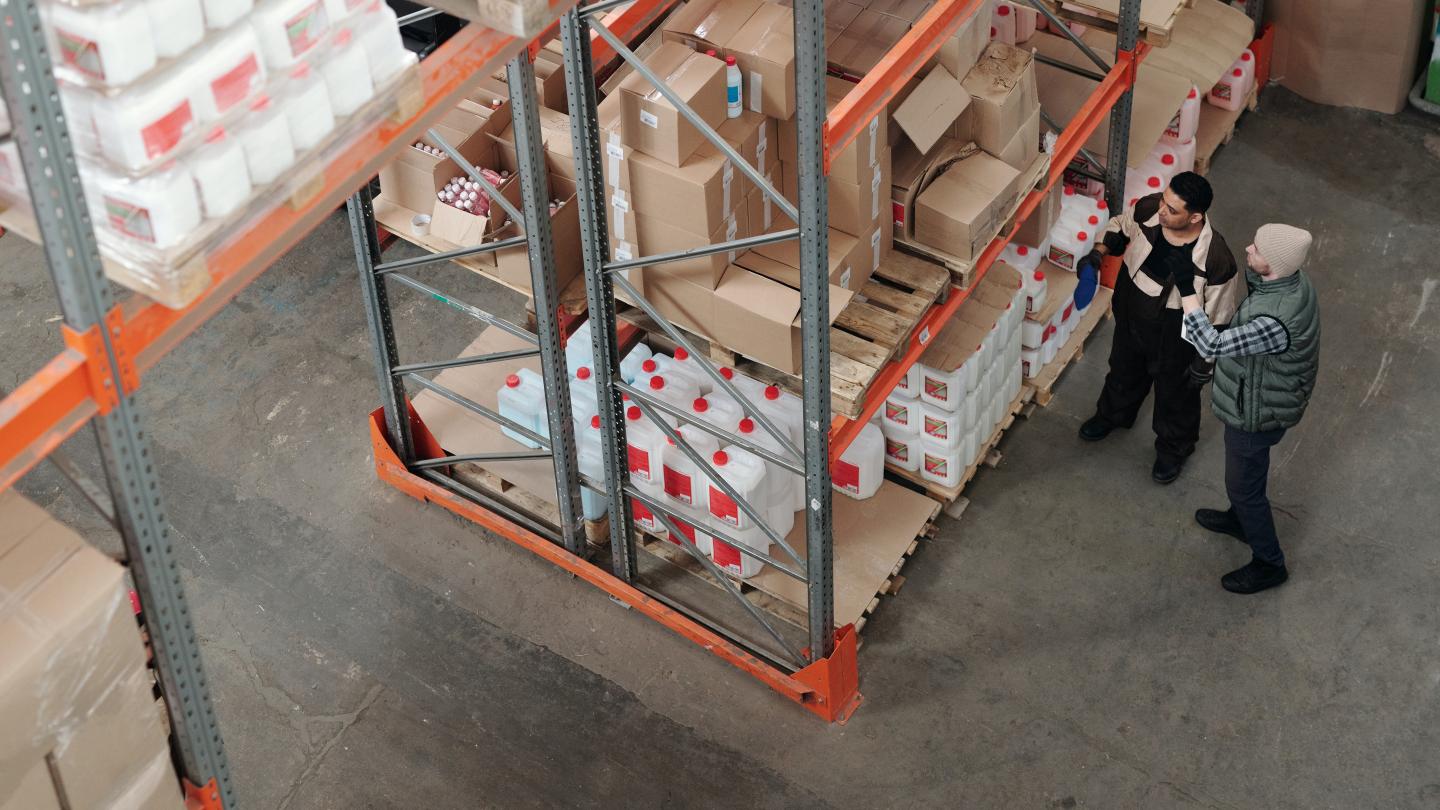 2 people checking inventory in a warehouse 2 people checking inventory in a warehouse