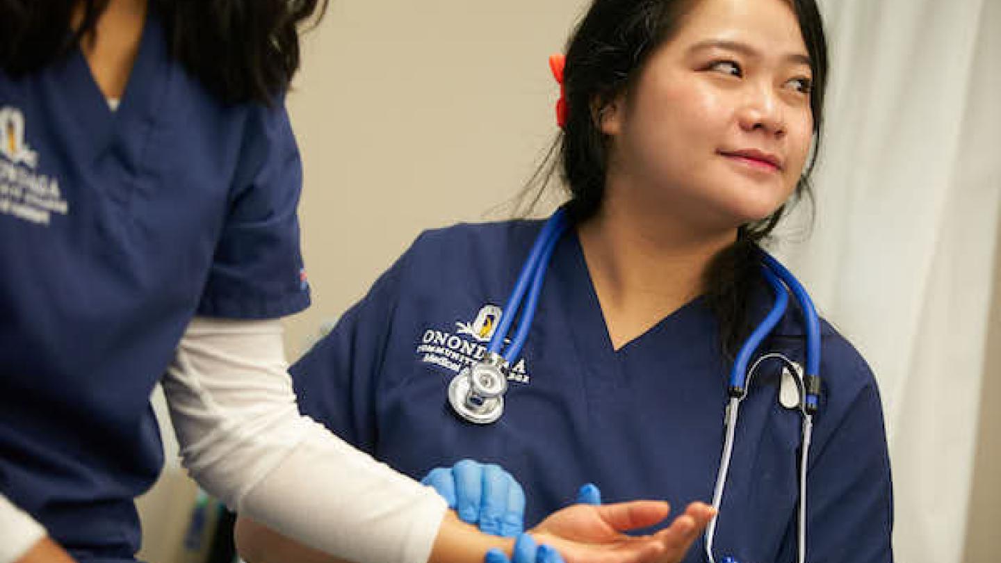 Student in the Medical Assistant Program taking a persons pulse.