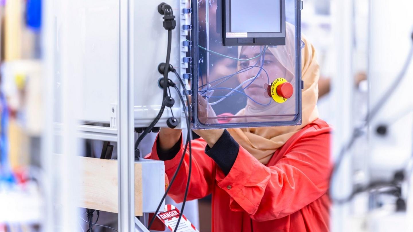 Person working on industrial control panel wiring.