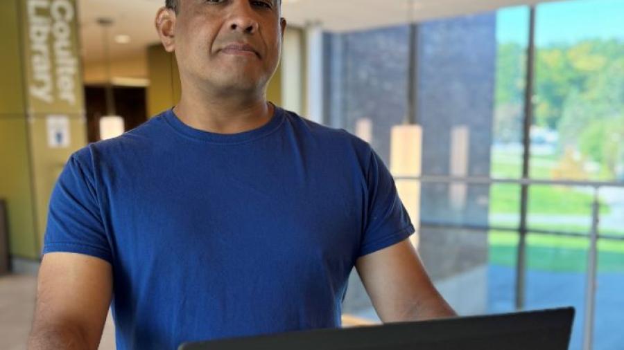 Justin Tani is a 48-year-old student in Onondaga Community College's Cybersecurity degree program. He's pictured in Coulter Library.