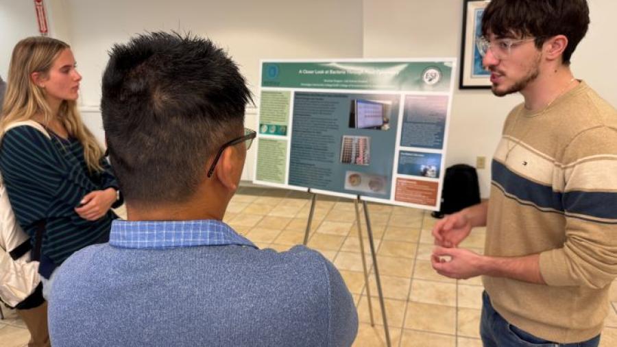 Nicholas Pangaro (right) discusses his research experience during a symposium in the Storer Auditorium Lobby. Pangaro is a Laboratory Sciences major who conducted research at SUNY-ESF during the summer.