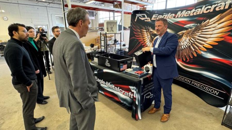 Michael Bower (right), a United States Marine Corps Veteran and owner of Eagle Metalcraft, shows one of the products his company makes.