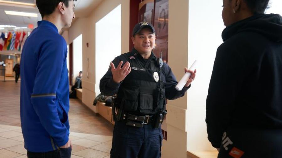 Onondaga Community College Peace Officer Rich Yung (center) speaks with students in the Gordon Student Center. Yung is the longest serving Peace Officer and the last original member of OCC's Campus Safety team.
