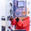 Person working on industrial control panel wiring.