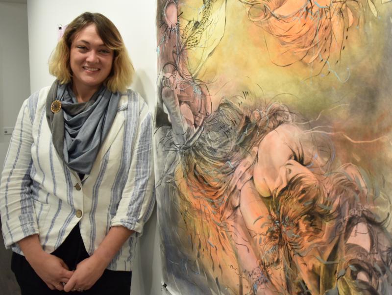 The work of Katie Gabriel is on display in OCC's gallery. Gabriel oversees Art in the Fayetteville-Manlius School District. She's pictured with &quot;Old Bones&quot; which consists of charcoal and watercolor on paper.