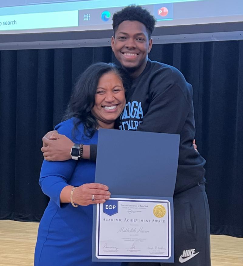 EOP Director Denise Valdes presents student Makhatub Hassan with his award for maintaining a cumulative 3.0 grade point average.