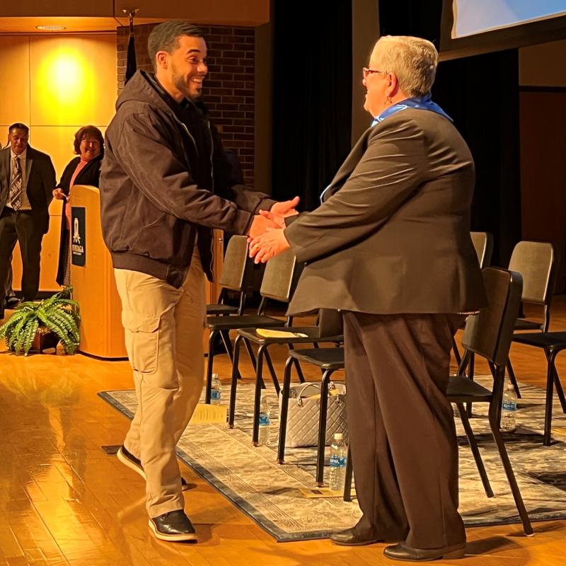 Angel Gonzalez (left) was welcomed into the Phi Theta Kappa honor society by OCC President Dr. Casey Crabill (right).