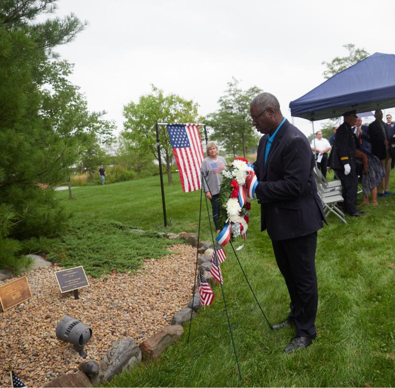 OCC President Dr. Warren Hilton places a wreath at the college's 9/11 memorial outside the Whitney Applied Technology Center.