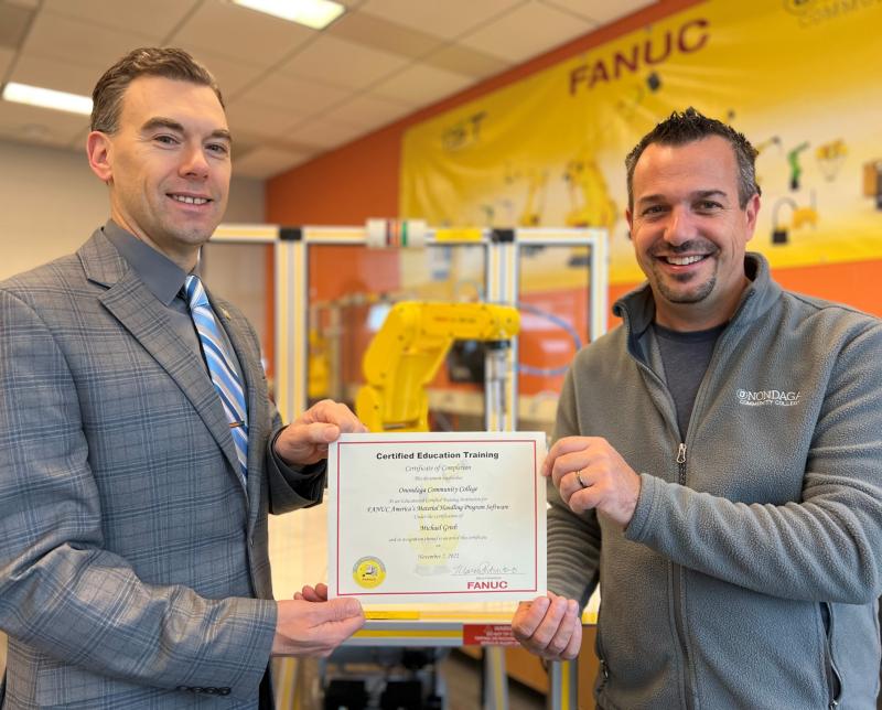 OCC Dean of Natural &amp; Applied Sciences Tim Stedman (left) and School of Computing &amp; Applied Technologies Chair Professor Mike Grieb show off a newly-earned certification for teaching students and those in workforce an industry standard in working with robotics.