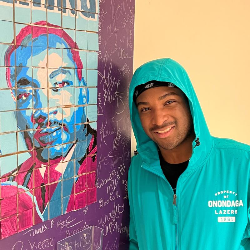 Joshua Newman will complete his General Studies degree this month. He's pictured next to a mosaic of Dr. Martin Luther King, Jr. which was made during Unity Day. Newman was on the Unity Day Advisory Board.
