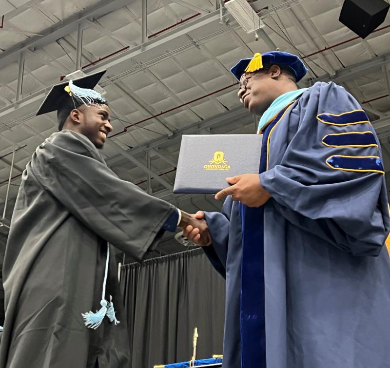Juhudi Boazi (left) receives his degree from OCC President Dr. Warren Hilton (right).