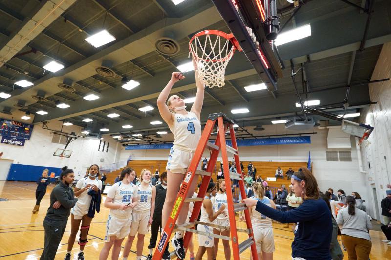 Student athlete cutting down the net after a game