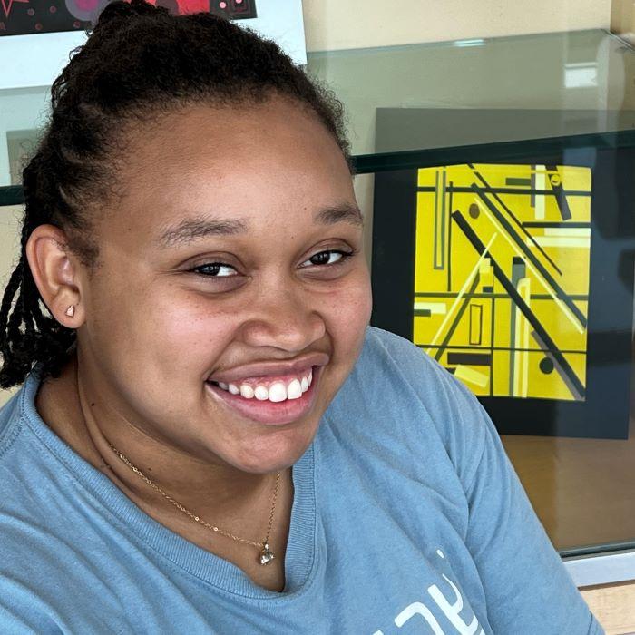Amya Graves is pictured in front of one her pieces of art which is on-display in the Whitney Applied Technology Center. She made it for her Color Theory class.