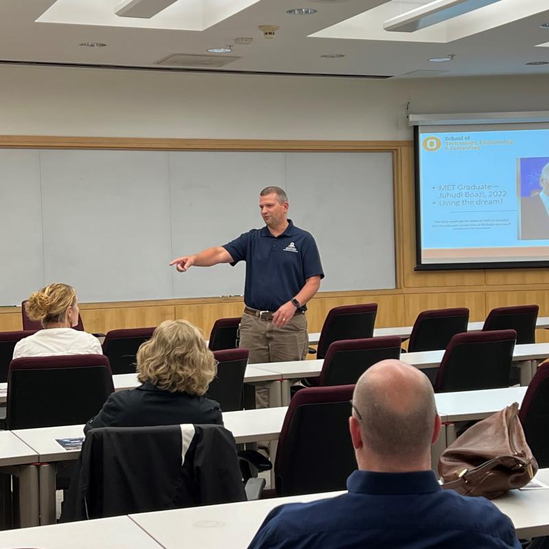 Professor Ryan Beckley speaks with high school teachers and industry representatives in the Whitney Applied Technology Center.