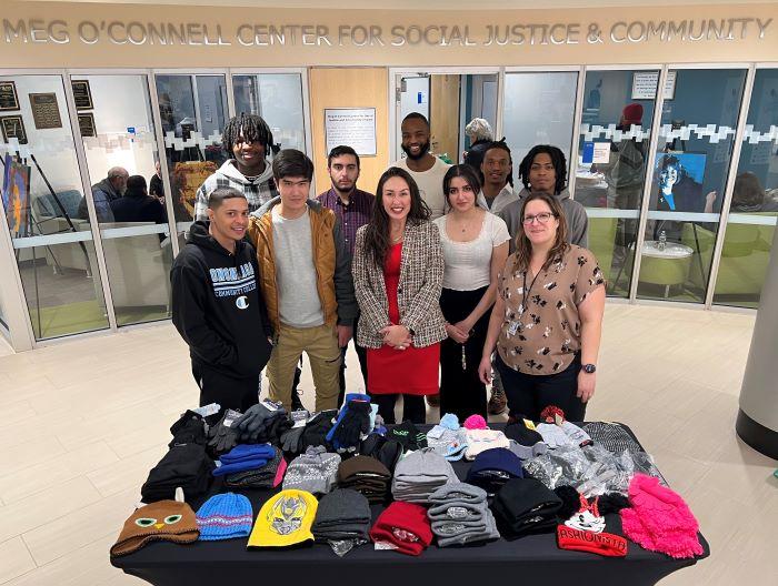 OCC student Taija Hanna (front row, center wearing red dress) led an effort to collect hats and gloves for students in Syracuse's Dr. Weeks Elementary School. Patty Sawmiller (front row, right) of Dr. Weeks came to campus to accept the donations.