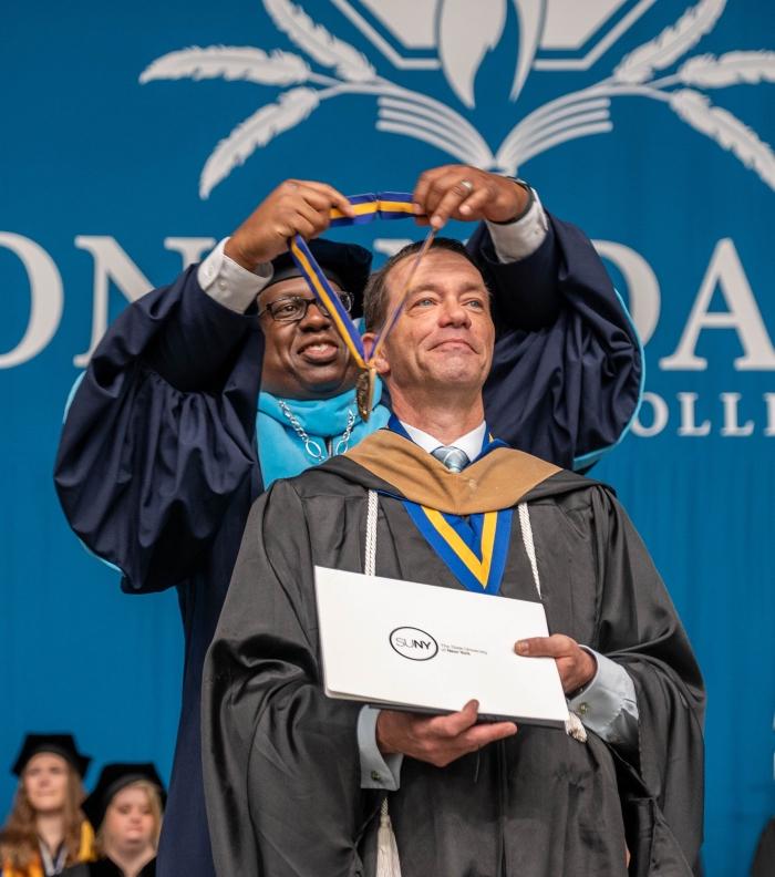 Chef James Taylor (right) receives his SUNY Chancellor's Award from OCC President Dr. Warren Hilton (left).