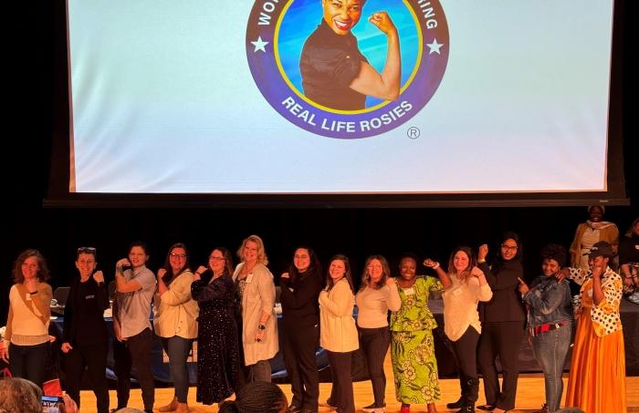 The first class of Real Life Rosies flex their biceps for a group photo.