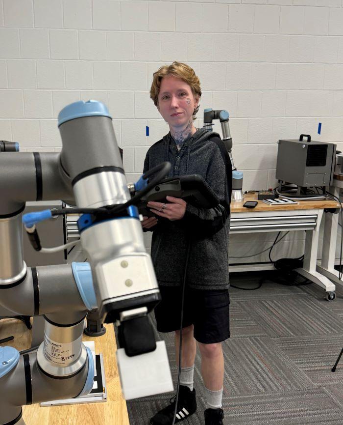 Dio Brown is a 35-year-old OCC student who is about to complete the Electromechanical Technology degree program, then pursue a bachelor's degree tuition-free. Dio is pictured in the robotics lab in the Whitney Applied Technology Center.