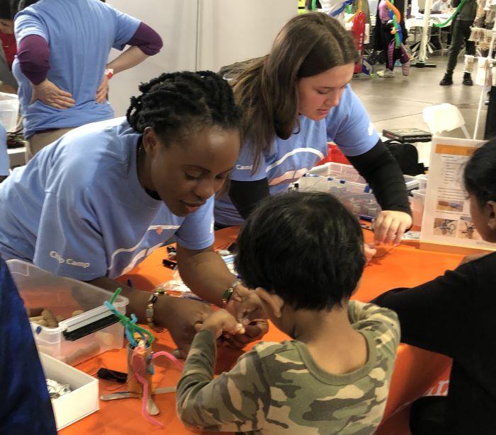 OCC students (left to right) Irielle Mwija and Claire Detor helped Maker Faire Syracuse attendees make wigglebots.