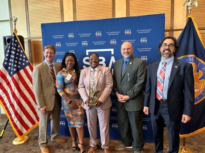 Shawni Davis (center) of Luminary Electrical receives the Small Business Administration's Small Business Person of the Year Award.