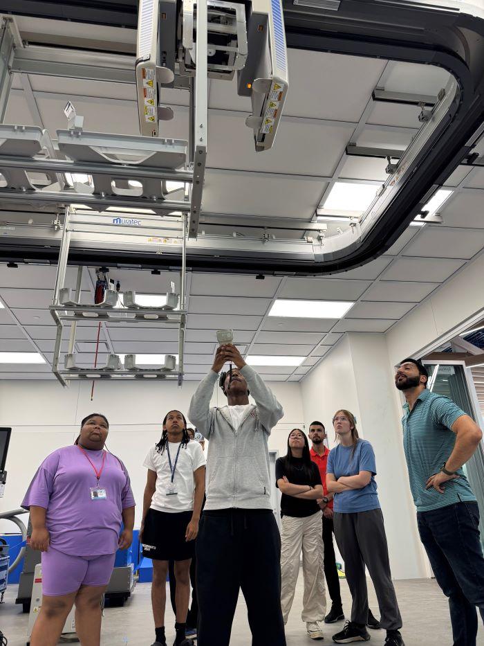 Students in the Pre-College Semiconductor Summer Program experiment with the robotics in the new Micron Cleanroom Simulation Lab on the Onondaga Community College campus.