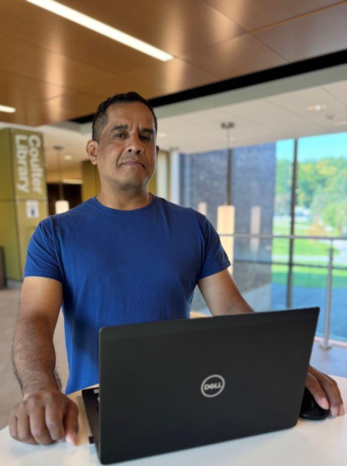 Justin Tani is a 48-year-old student in Onondaga Community College's Cybersecurity degree program. He's pictured in Coulter Library.