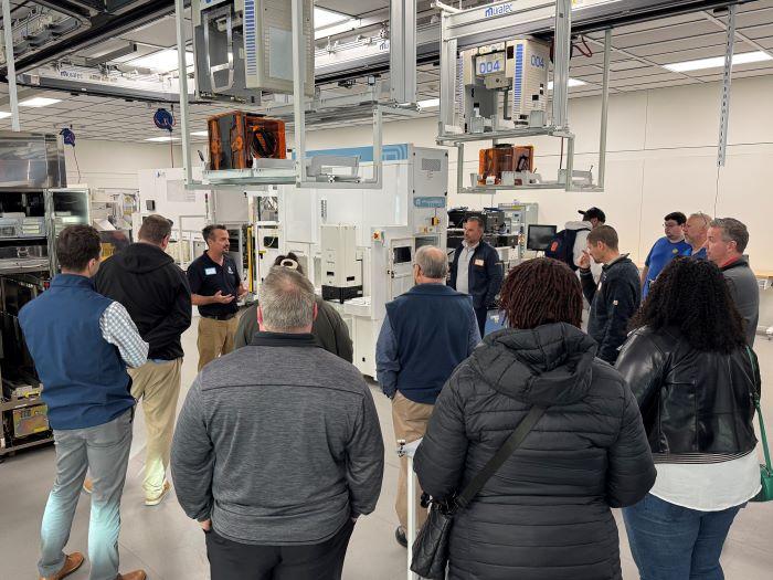 Professor Mike Grieb speaks with industry partners in the Micron Cleanroom Simulation Lab on the Onondaga Community College campus.