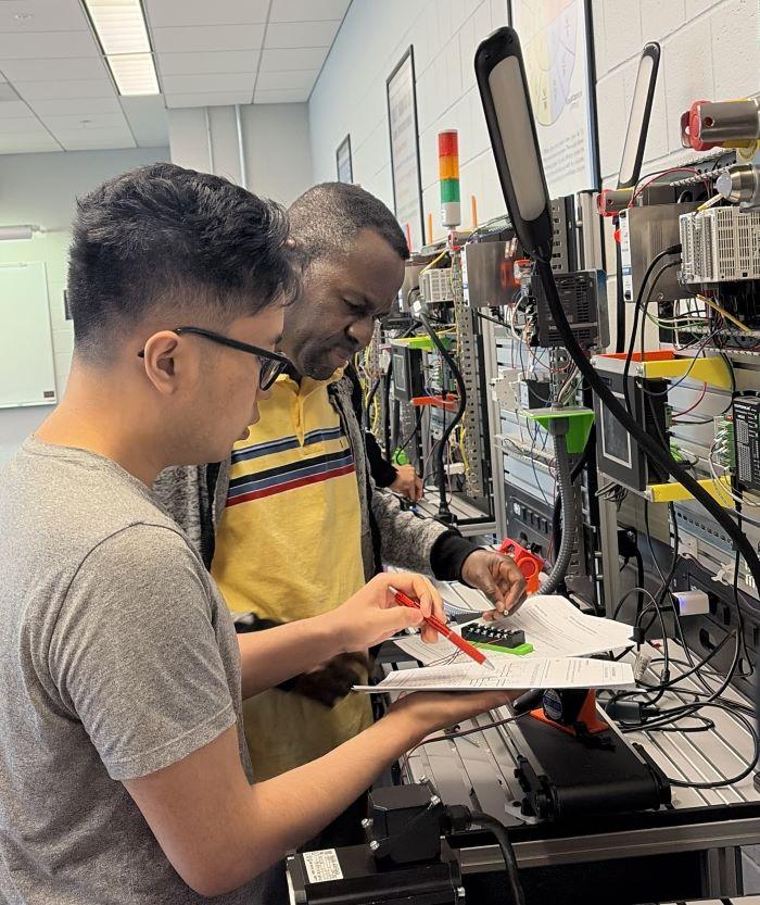 Aaron Unger (left) and Cyrille Kayembe Asagnion (right) work together during the Semiconductor Bootcamp.